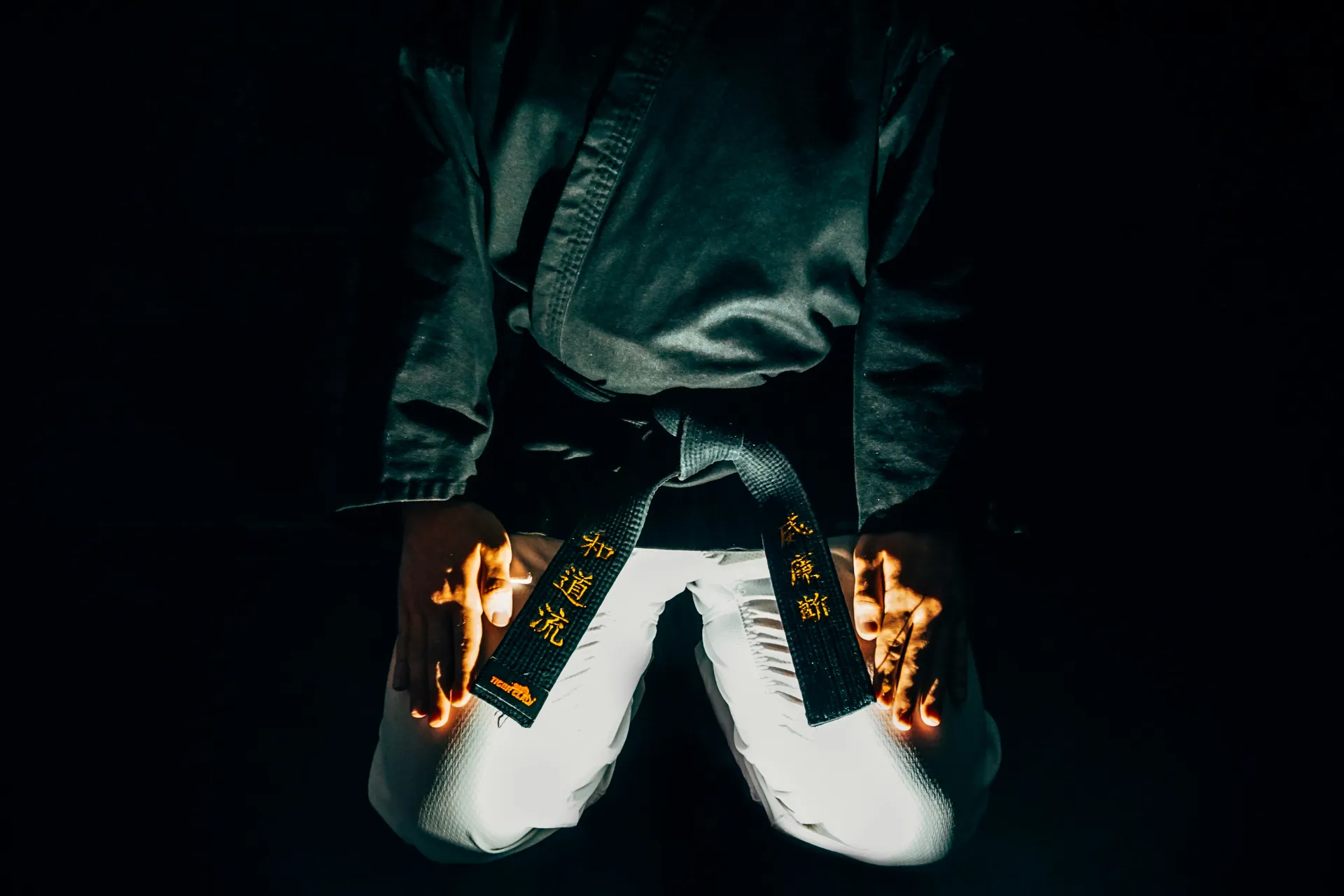 유도에서 검정띠를 착용한 사람의 모습으로 권위와 책임을 상징